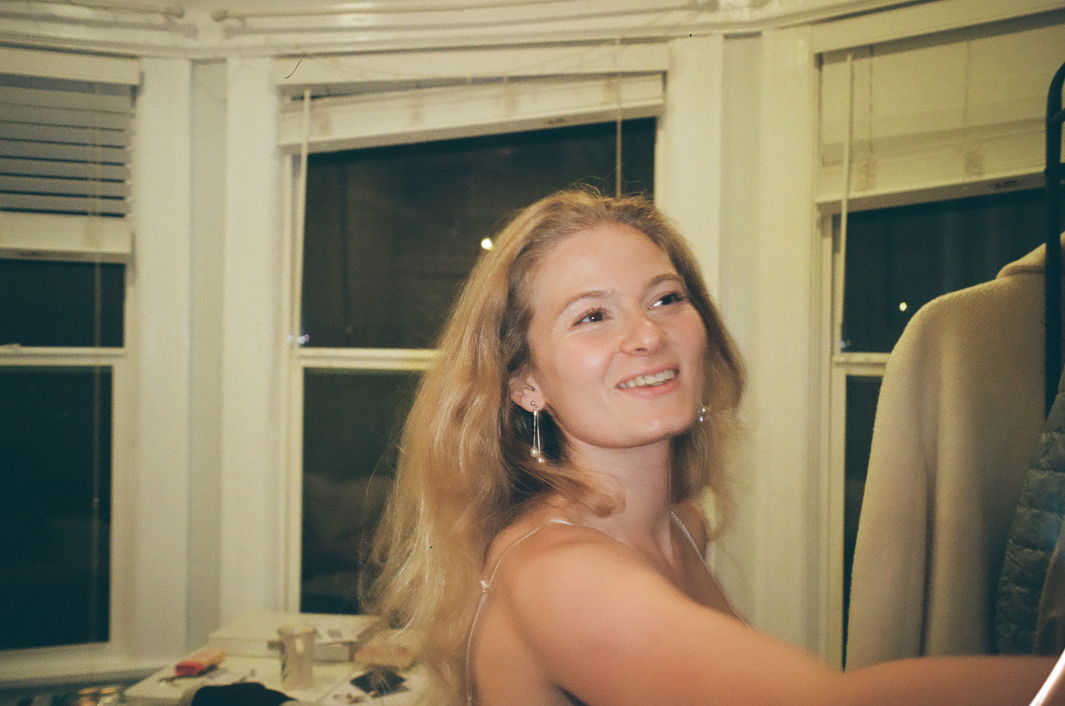 A woman laughing, turning toward the camera