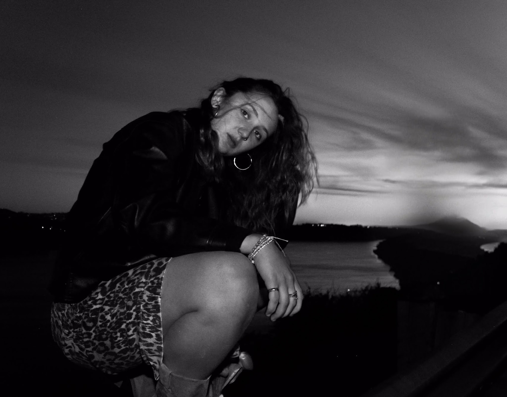 Stella Mettifogo, crouched on a hillside above the bay at dusk